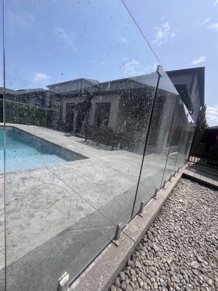 Dirty glass pool railing before window washing in London, Ontario